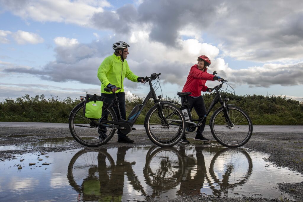 Paddy and Anna Lane of Mallow, Co. Cork looking at each other about the cycle their electric bicycles.