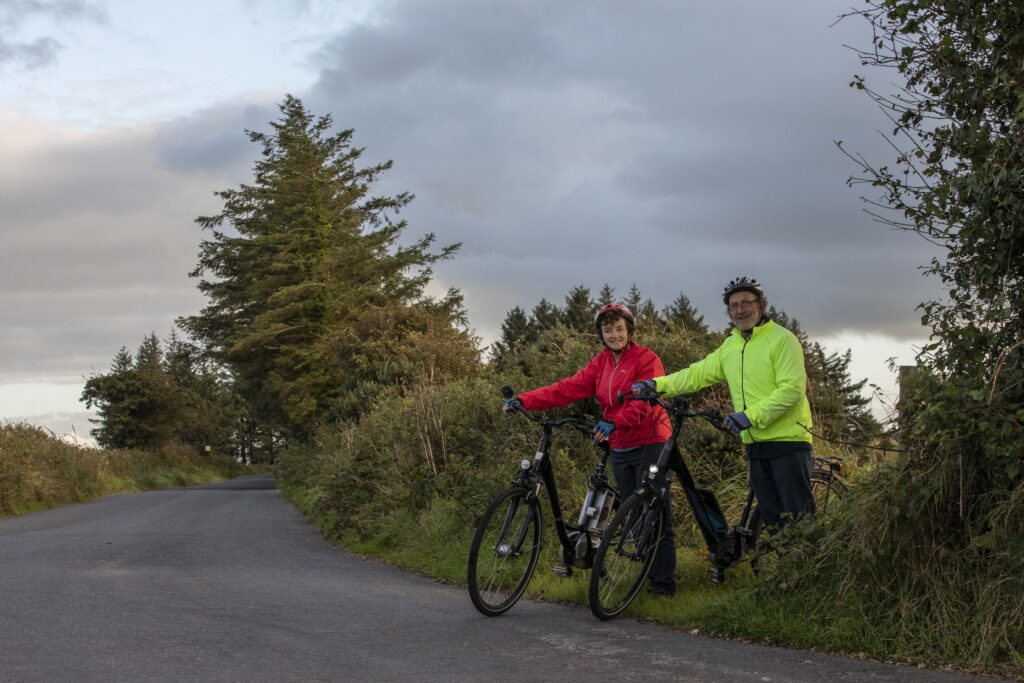 Paddy and Anna Lane of Mallow, Co. Cork exiting a field onto a country road with their electric bicycles.