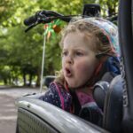 A young girl riding in an electric cargo bicycle.
