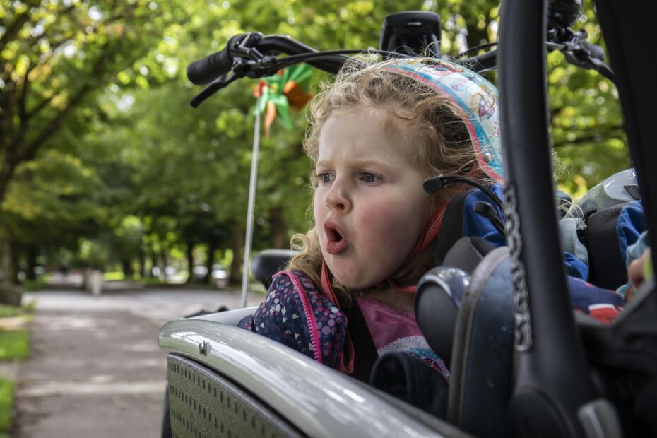 A young girl riding in an electric cargo bicycle.